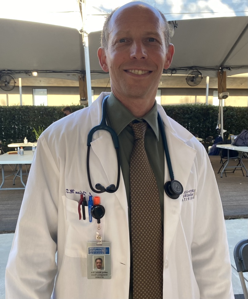 Randy Loveridge in full doctor wardrobe with a white coat and stethoscope on the set of Grey's Anatomy